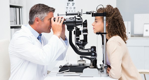 The ophthalmologist checks the patient's eyesight